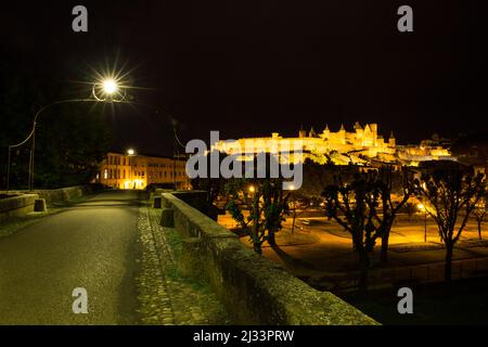 Carcassonne mittelalterliche Zitadelle (Cité Médiévale) und Brücke beleuchtet in der Nacht Stockfoto