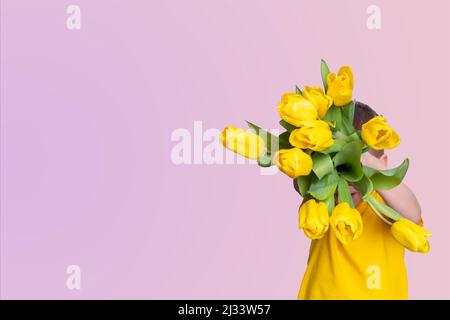 Junge mit einem Strauß gelber Tulpen auf einem rosa Hintergrund, Kopierraum, Draufsicht. Geschenk für Mama. Frühlingsblumen. Stockfoto