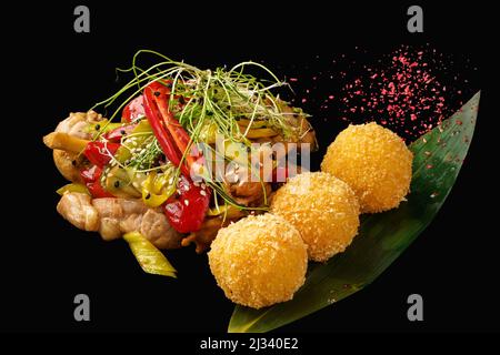 Asiatische Wok Huhn Oberschenkel, Reis, Pilze, Paprika, Chili, Grüne Zwiebel, Lauch, Teriyaki-Sauce, Sojasauce, Sesam. Isoliert auf schwarzem Backgroun Stockfoto