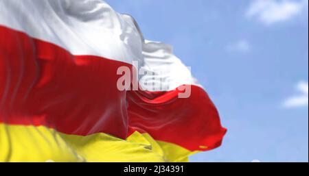 Detail der Nationalflagge Südossetiens, die an einem klaren Tag im Wind winkt. Südossetien ist ein abtrünnigen Staat im Südkaukasus. Stockfoto