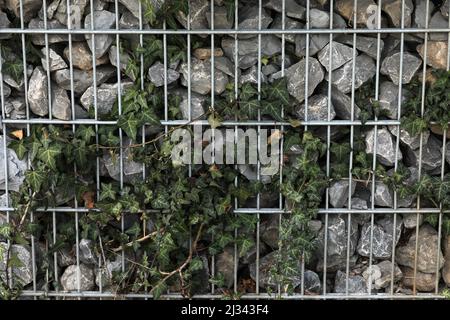 Zaun mit Gabionen und Steinen Stockfoto