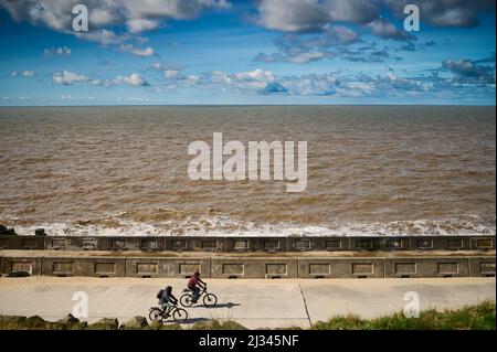 Zwei Radfahrer, die an sonnigen Tagen den unteren Weg in Bispham, Blackpool, entlang fahren Stockfoto