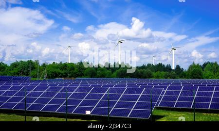 Sonnenkollektoren und Windturbinen erzeugen Strom in Kraftwerk grüne Energie erneuerbare mit blauem Himmel Hintergrund Stockfoto