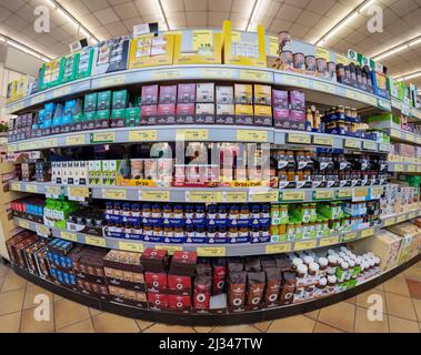 Fossano, Italien - 30. März 2022: Regale mit Verpackungen von Kaffee, Marmeladen und Kräutertees zum Verkauf in einem italienischen Supermarkt, Fischauge Vision Stockfoto