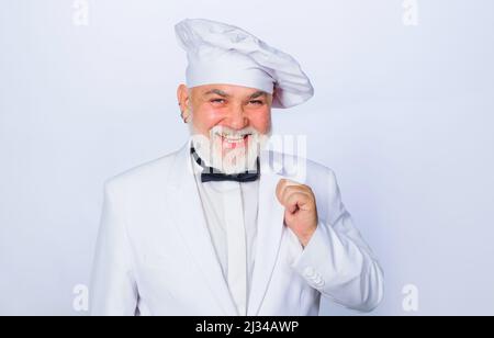 Professioneller Koch, Koch oder Bäcker in weißer Uniform. Lächelnder bärtiger Mann. Kochkonzept. Stockfoto