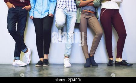 Warten auf die Glocke. Ausgeschnittene Aufnahme einer Gruppe von nicht erkennbaren Studenten, die auf dem Campus in einem Korridor stehen. Stockfoto