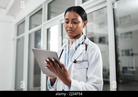 Fortschritte in der Medizin finden immer statt. Aufnahme eines jungen Arztes mit einem digitalen Tablet in einem Krankenhaus. Stockfoto