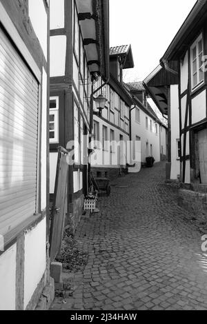 Eine Graustufenansicht eines Pfades zwischen Fachwerkhäusern Stockfoto