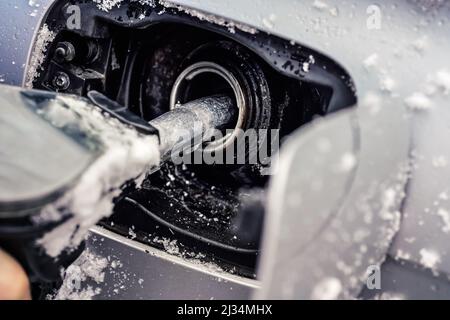 Metall-Kraftstoffdüse, Füllen des Gastanks des Autos mit Schnee im Winter bedeckt, Nahaufnahme Detail Stockfoto