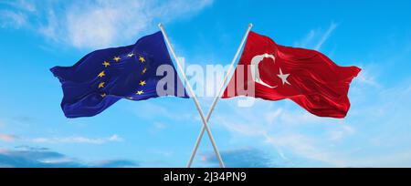 Zwei gekreuzte Flaggen, die die Europäische Union und die Türkei bei bewölktem Himmel im Wind winken. Konzept der Beziehung, des Dialogs, des Reisens zwischen zwei Ländern. 3D il Stockfoto