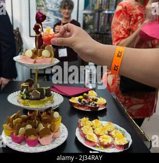 London, UKI. Tea Time mit Miss, USA. 5. April 2022. Elizabeth Bennett und Mr Darcy auf der London Book Fair 2022. Flametere Publishing veranstaltete eine Nachmittagstee-Party mit elegantem porzellan, hervorragendem Tee und einer Fülle von Kuchen und Leckereien, die das Thema der englischen Literatur widerspiegeln. Kredit: Peter Hogan/Alamy Live Nachrichten Stockfoto