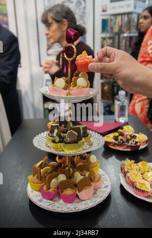 London, UKI. Tea Time mit Miss, USA. 5. April 2022. Elizabeth Bennett und Mr Darcy auf der London Book Fair 2022. Flametere Publishing veranstaltete eine Nachmittagstee-Party mit elegantem porzellan, hervorragendem Tee und einer Fülle von Kuchen und Leckereien, die das Thema der englischen Literatur widerspiegeln. Kredit: Peter Hogan/Alamy Live Nachrichten Stockfoto