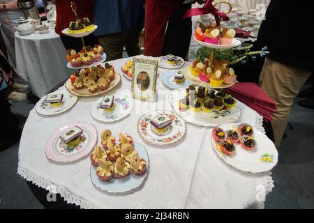 London, UKI. Tea Time mit Miss, USA. 5. April 2022. Elizabeth Bennett und Mr Darcy auf der London Book Fair 2022. Flametere Publishing veranstaltete eine Nachmittagstee-Party mit elegantem porzellan, hervorragendem Tee und einer Fülle von Kuchen und Leckereien, die das Thema der englischen Literatur widerspiegeln. Kredit: Peter Hogan/Alamy Live Nachrichten Stockfoto