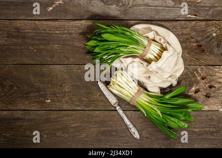 Trauben einer frischen Ernte von Frühlingsramson oder wildem Lauch. Duftende würzige Blätter auf Vintage-Holztisch Hintergrund, hartes Licht, dunkler Schatten, Draufsicht Stockfoto