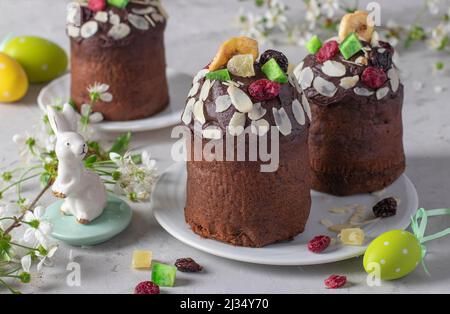 Schokoladen-Osterkuchen mit kandierten Früchten auf hellgrauem Hintergrund. Osterfrühling Stillleben Stockfoto