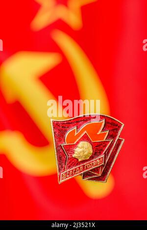 Anstecknadel der sowjetischen russischen Senior Young Pioneers mit Motto Always Ready! (ВСЕГДА ГОТОВ! = Vsegda Gotov) mit sowjetischer russischer Flagge. Stockfoto