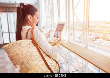 Frau mit Kreditkarte, die online auf einem Tablet-Computer in einem Einkaufszentrum einkauft Stockfoto