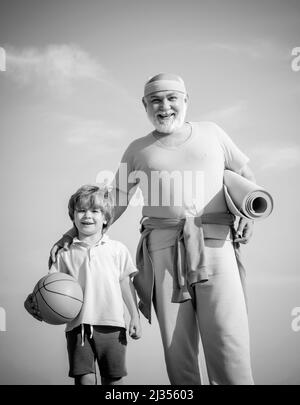 Vater und Sohn sportlich - Familienzeit zusammen. Sport zu treiben ist kostenlos. Familiensport. Porträt eines gesunden Vaters und Sohnes, der am blauen Himmel arbeitet Stockfoto