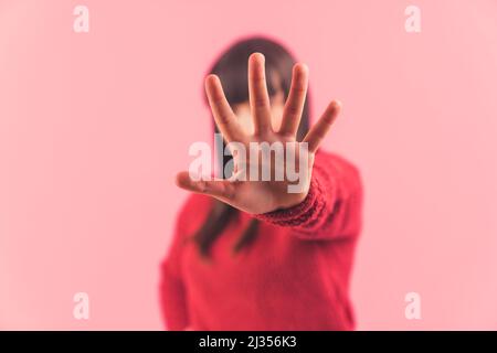 Stoppschild, Handfläche, Hand an der Kamera, Symbol. Fokus auf den Vordergrund. Studio mit rosa Hintergrund aufgenommen. Hochwertige Fotos Stockfoto