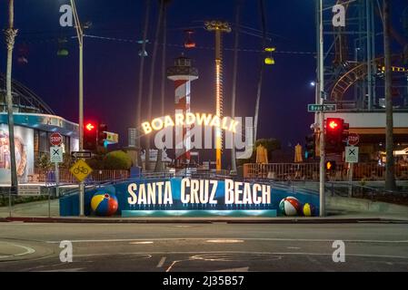 SANTA CRUZ, CA-MAR 31, 2022: Nachtansicht des Santa Cruz Beach Boardwalk, vom Vordereingang mit seinem hellen Neonschild aus gesehen. Der Vintage Seaside am Stockfoto