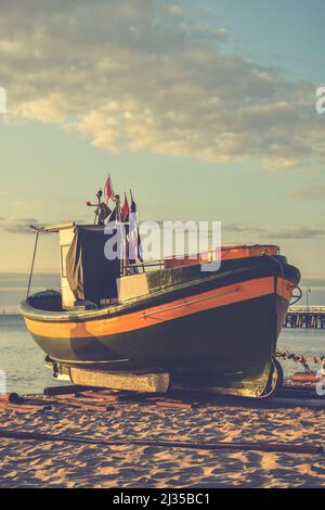 Schöner Morgenblick an der polnischen Küste in Gdynia. Schiff auf einem Sandstrand am Morgen. Stockfoto