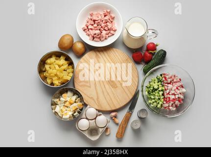 Zutaten für die Zubereitung von leckeren Okroshka auf grauem Hintergrund Stockfoto