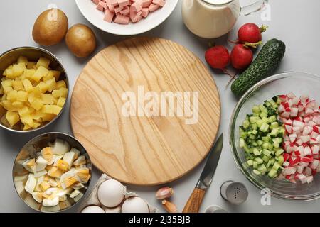 Zutaten für die Zubereitung von leckeren Okroshka auf grauem Hintergrund, Nahaufnahme Stockfoto