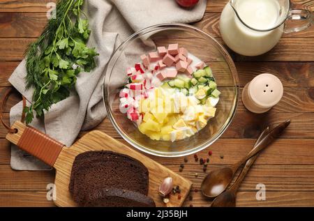 Zutaten für die Zubereitung schmackhafter Okroshka auf Holzgrund, Nahaufnahme Stockfoto