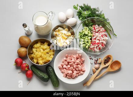 Zutaten für die Zubereitung von leckeren Okroshka auf grauem Hintergrund Stockfoto