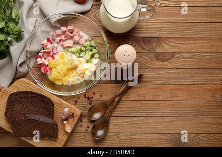 Zutaten für die Zubereitung schmackhafter Okroshka auf Holzgrund, Nahaufnahme Stockfoto