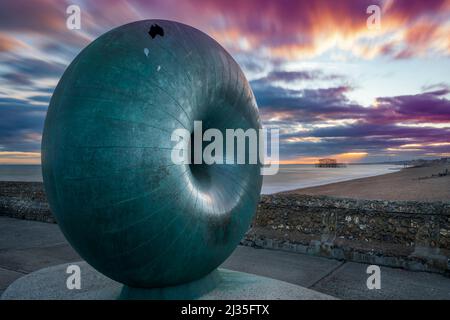 „Afloat“ ist ein großer, kreisförmiger, in Bronze gegossener Globus in Donut-Form, der sich an der Strandpromenade von Brighton befindet. Die Skulptur wird als Pos. Stockfoto