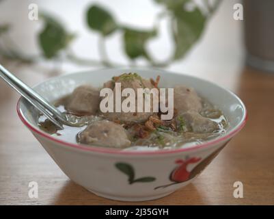 Fleischbällchen-Suppe mit Reisnudeln auf vintage asiatische Schüssel & Holztisch und Blur backgorund Bakso Sapi dengan Mangkok Vintage Stockfoto