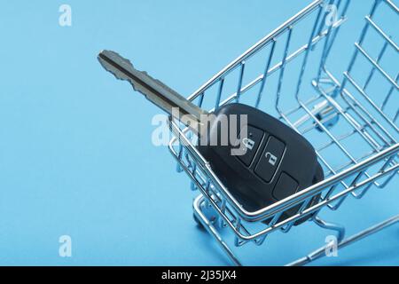 Autoschlüssel in einem Korb auf blauem Hintergrund. Stockfoto