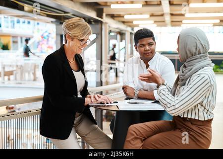 Sie haben alle brillante Ideen zu teilen. Aufnahme einer Gruppe von Geschäftsleuten, die in einem Büro eine Diskussion führen. Stockfoto