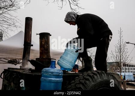 Lviv, Ukraine. 05. April 2022. Ein ukrainischer Freiwilliger fühlt eine Feldküche mit Wasser am Hauptbahnhof in Lemberg, Ukraine, während die russische Invasion in der Ukraine fortgesetzt wird - 5. April 2022. Während die Russische Föderation in die Ukraine einmarschiert, wird der Konflikt voraussichtlich bis zu 5 Millionen Ukrainer zur Flucht zwingen und eine große Anzahl interner Flüchtlinge schaffen. Die Ukrainer brauchen dringend medizinische Versorgung, Lebensmittel, Kleidung und mehr. Russische Streitkräfte betraten das Territorium der Ukraine am 24. Februar 2022. (Foto von Dominika Zarzycka/Sipa USA) Quelle: SIPA USA/Alamy Live News Stockfoto