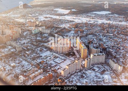 Flugflug bei Sonnenuntergang oder Morgendämmerung. Der Flügel und das Land des Flugzeugs werden durch den Strahler gesehen. Blick aus dem Fenster des Flugzeugs. Flugzeug, Flugzeug. Trave Stockfoto