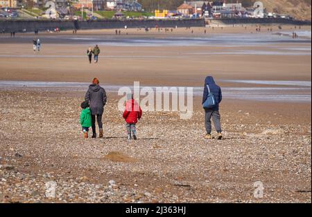 Familiengruppe, die am Strand spazieren geht Stockfoto