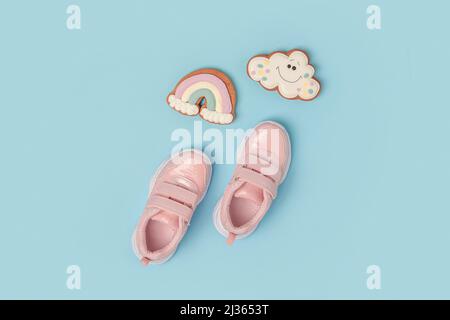 Sportschuhe, pinke Sneaker und niedliche Lebkuchen auf dem Hintergrund. Sommerzeitkonzept. Draufsicht Flat Lay. Stockfoto