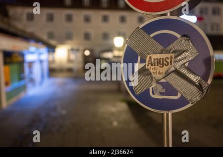 München, Deutschland. 06. April 2022. Ein Schild am Viktualienmarkt in der Innenstadt, das darauf hinweisen soll, dass eine Maske getragen wird, ist mit Klebeband durchgestrichen und mit einem Aufkleber mit dem Wort 'Angst' versehen. Kredit: Peter Kneffel/dpa/Alamy Live Nachrichten Stockfoto