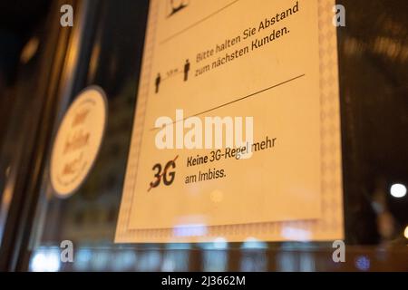 München, Deutschland. 06. April 2022. Ein Schild am Eingang eines Ladens in der Innenstadt weist darauf hin, dass die Regel von 3G im Snackbereich nicht mehr gilt. Kredit: Peter Kneffel/dpa/Alamy Live Nachrichten Stockfoto