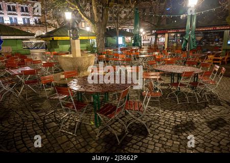 München, Deutschland. 06. April 2022. In den frühen Morgenstunden liegt Regenwasser auf den leeren Tischen eines Biergartens auf dem Viktualienmarkt. Kredit: Peter Kneffel/dpa/Alamy Live Nachrichten Stockfoto