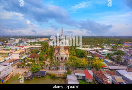 Luftaufnahme der berühmten Cai Be Kirche im Mekong Delta, römischer Baustil. Vorne ist Cai Be Floating Market, Tien Giang, Vietnam. Trave Stockfoto