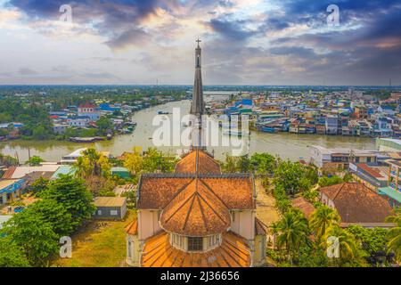 Luftaufnahme der berühmten Cai Be Kirche im Mekong Delta, römischer Baustil. Vorne ist Cai Be Floating Market, Tien Giang, Vietnam. Trave Stockfoto