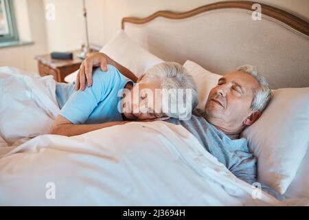 Ich habe diesem Herzschlag jahrelang zugehört. Eine kurze Aufnahme eines liebevollen Seniorenpaares, das sich beim Schlafen im Bett eines Pflegeheims kuschelt. Stockfoto