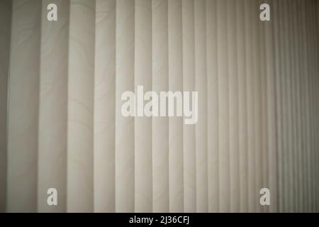 Weiße Jalousien. Tageslicht durch Jalousien. Sonnenschutz im Zimmer. Details zur Innenausstattung. Stockfoto