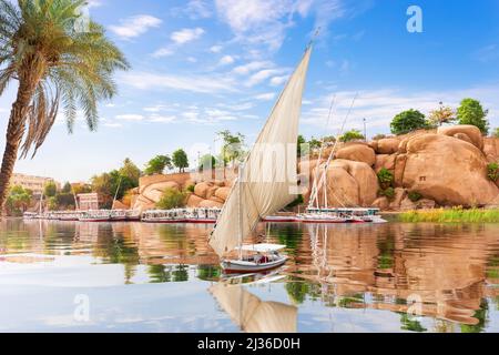 Der Nil und Segelboote vor den traditionellen Gebäuden von Assuan, Ägypten Stockfoto