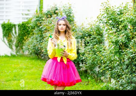 Teenager Mädchen Pflanzen im Garten. Teenager schwimmt im Garten. Blumen Pflanzen. Stockfoto