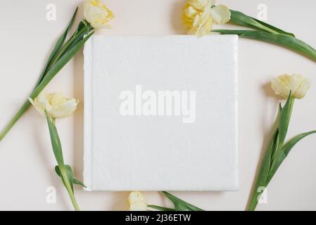 Hochzeit oder Familie Fotoalbum, gelbe Tulpen Blumen auf hellem Hintergrund; Draufsicht, flach liegend, Draufsicht Stockfoto