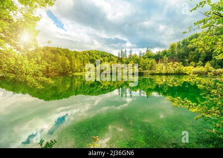 Die Sonne am Wasserfall Veliki Prstavac spiegelt sich im Potok Plitvice See des Nationalparks Plitvice in Kroatien wider. UNESCO-Weltkulturerbe von Kroatien Stockfoto