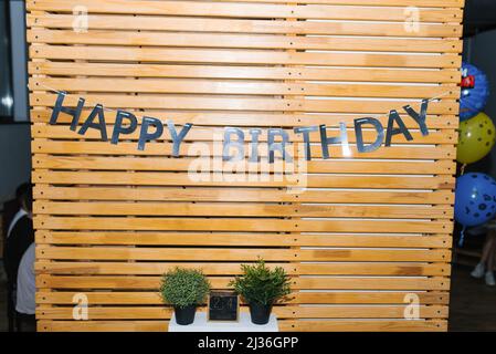 Die Inschrift 'Happy Birthday' auf der Holzwand. Fotozone für den Urlaub Stockfoto